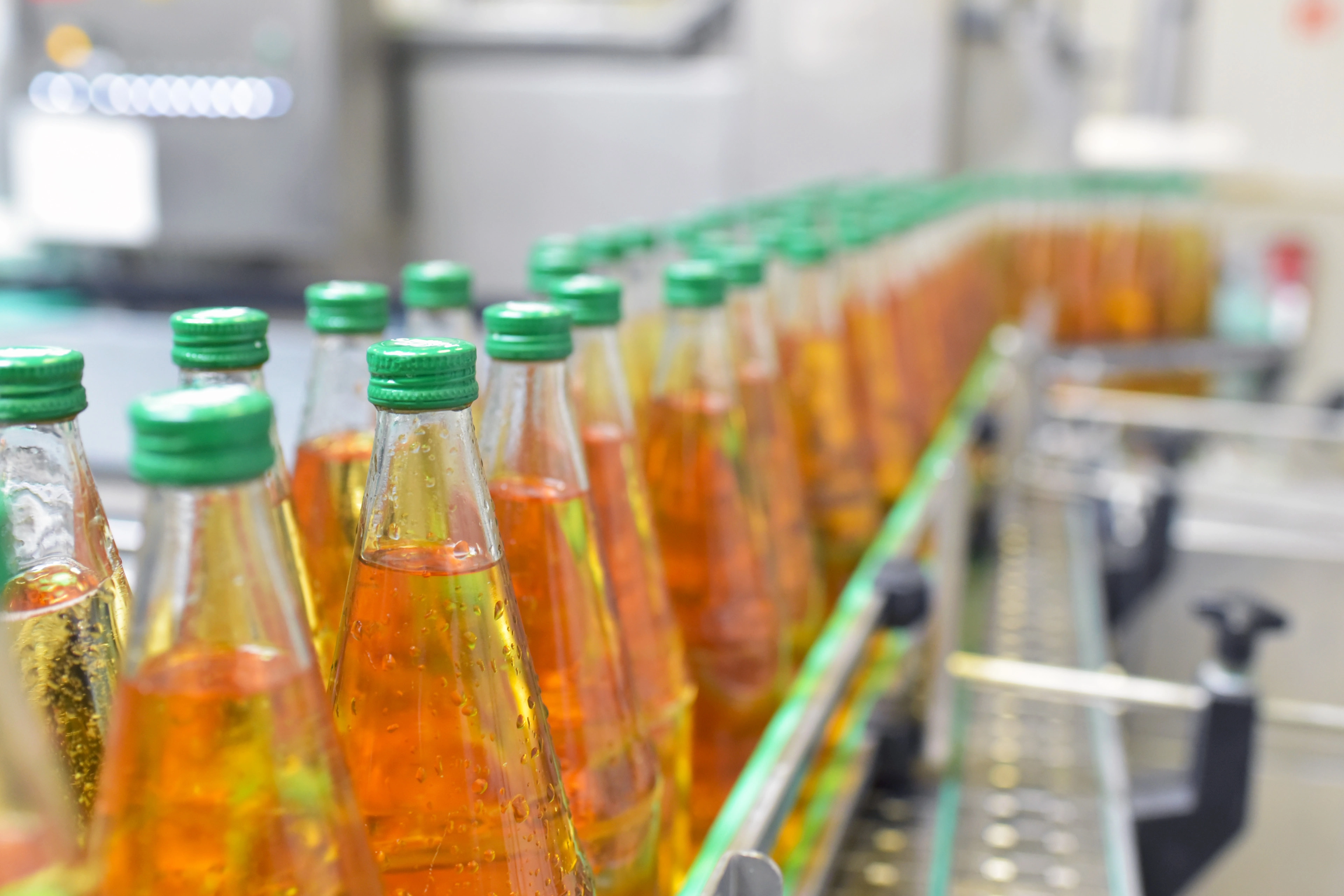 Close-up image of apple juice bottles in the filling system