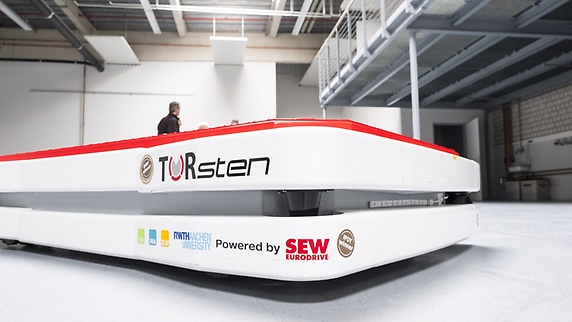 Valkoinen AGV-ratkaisu, jossa on sana  "TORsten" ja  SEW‑EURODRIVE-logo