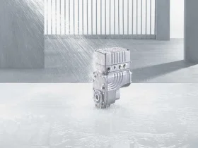 Grey MOVIGEAR® drive unit on a concrete substrate that is sprayed with water