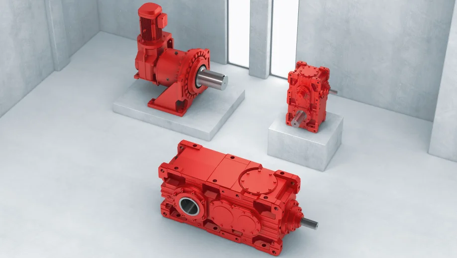 Three different red industrial gear units in the X series against a concrete background